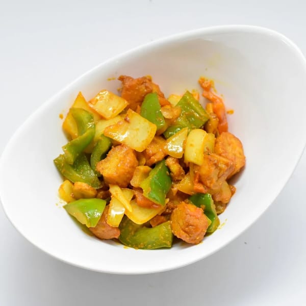 Shan-E-Panjab's Indian dish with paneer, green bell peppers, and onions in a white bowl.