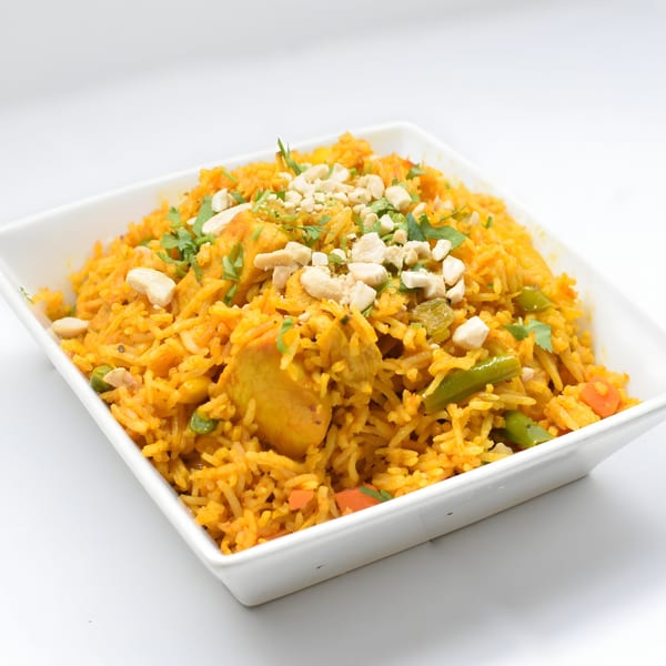 Shan-E-Panjab's chicken biryani, a vibrant Indian rice dish with chicken, vegetables, and cashews.